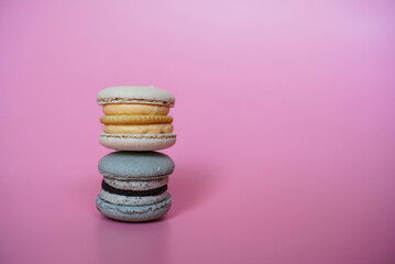 Two macarons condo. Macaron with cheese and cookies flavour on pink color background.