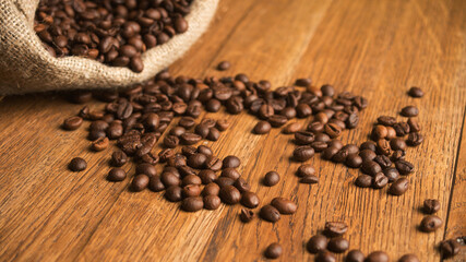 Fototapeta na wymiar Fresh coffee beans on wood and linen bag, ready to brew delicious coffee