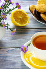 White cup of tea with lemon, bun, bagel and cookies. Lunch break at a coffee shop