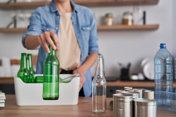 Woman recycling garbage at domestic kitchen