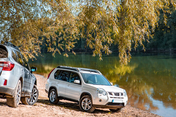 two cars parked at autumn river beach