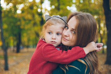 mother daughter love hug at autumn city park