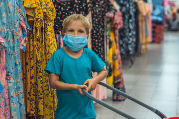 A new normal. Caucasian boy in sanitary face mask shopping in supermarket. Kid with buying basket. Child wearing protective against coronavirus. Safety, health protection during covid-19 quarantine