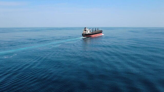 Large cargo ship. A bulk carrier carries cargo across the ocean. Transportation. Delivery. Logistics. A large ship for transporting. Aerial 4k shot.