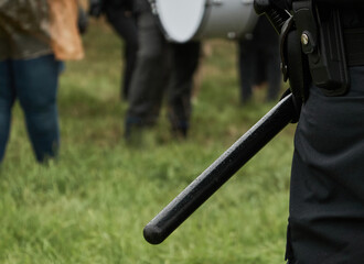 Baton on the belt of the black uniform of a German police officer