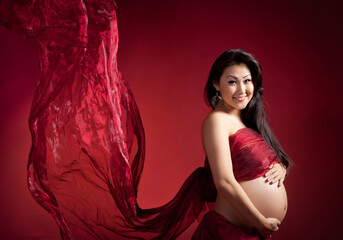 Pregnant woman with red clothing on red background