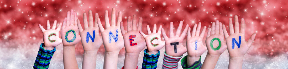 Children Hands Building Colorful English Word Connection. Red Snowy Christmas Winter Background With Snowflakes And Sparkling Lights