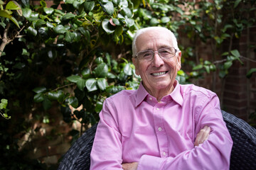 Naklejka na ściany i meble Portrait Of Smiling Senior Man Relaxing In Garden At Home