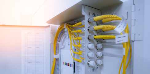 fiber optic cable connected to enclosure box in a technology data center room. Selective focus