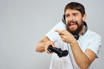 Man with gamepad headphones playing leisure technology white t-shirt light background