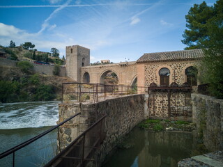 Old mill of the Tagus river as it passes through Toledo, Spain, next to the San Martín Bridge,