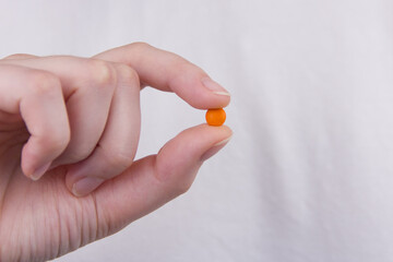 orange pill in female hand