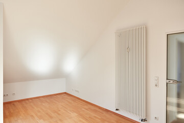 Empty room in attic apartment with radiator