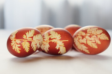 Painted Easter eggs on a white background. Floral pattern on a red eggshell. Festive food.