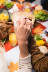 cropped view of senior couple holding hands on thanksgiving