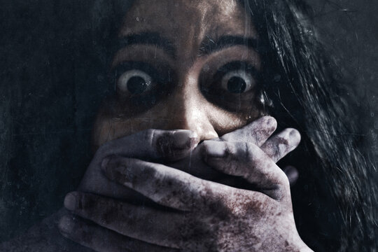 Scared woman on dark background