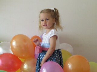 little girl playing with air balloons