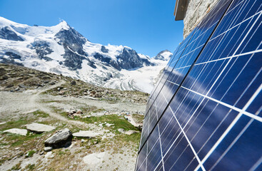 Close-up perspective snapshot of solar panels installed on the walls of alpine hut in Swiss Alps as...