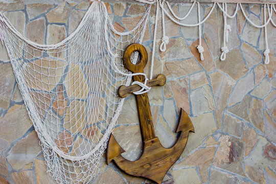 Stone wall with anchor and rope net decor.