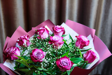 Bouquet with two-color roses in a purple package.