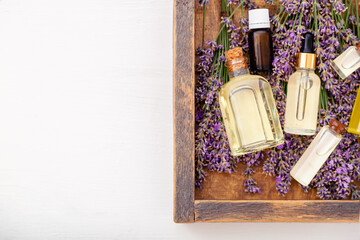 Oil serum oils on lavender flowers in wooden box. Lavender essential oil, serum, body butter, massage oil, liquid. Flat lay copy space. Skincare lavender cosmetics products. Set spa beauty products