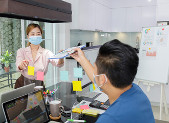 Asian small business start up working with laptop and  PC. Group of asian people teamwork work from Private Home Office social distancing among Coronavirus outbreak Soft focus photo