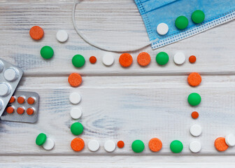 Medical flatlay with colourful pills and mask. New year medical concept. Space for text.
