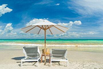 Beach chairs on the sand beach with cloudy blue sky