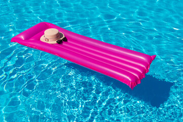 Beach summer holiday background. Inflatable air mattress and hat on swimming pool.;