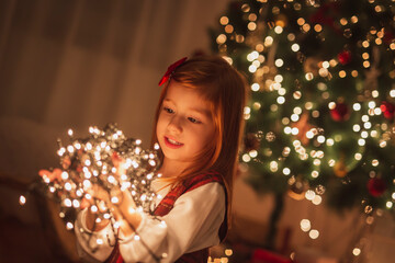 Obraz na płótnie Canvas Little girl holding bunch of Christmas lights