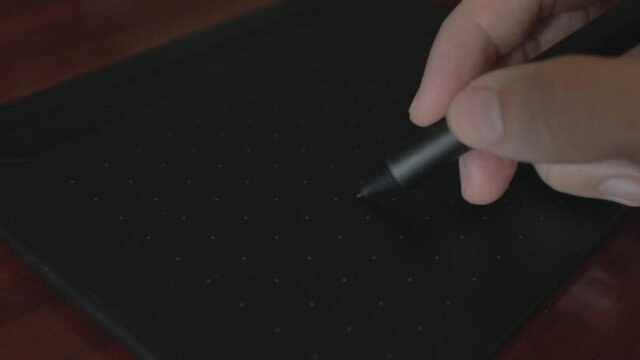 Close up view of graphic designer Drawing with the stylus on a graphics tablet