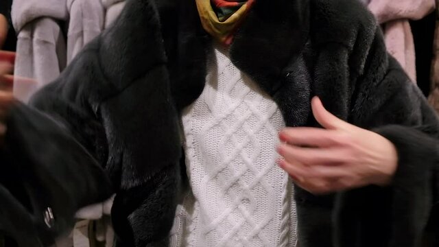Close up on a woman wearing luxury black mink fur coat. Winter fashion model. Mink fur coat collection