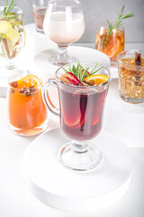 Various autumn winter alcohol drinks set. Different seasonal alcohol cocktails - mulled wine, glogg, grog, eggnog, ginger ale, hot buttered rum, punch, apple cider, sangria, white background