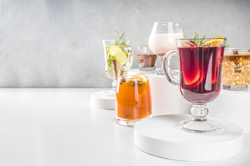 Various autumn winter alcohol drinks set. Different seasonal alcohol cocktails - mulled wine, glogg, grog, eggnog, ginger ale, hot buttered rum, punch, apple cider, sangria, white background