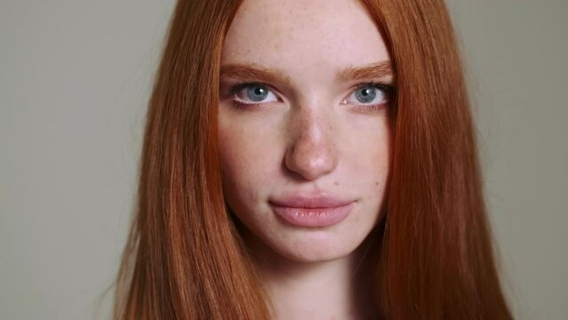 Young pretty redhead woman opening eyes isolated over white wall background