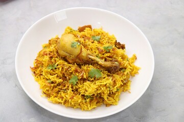 Chicken Biryani/murg Pulao.  Garnished with fried onion & chopped coriander. Biryani served with raita is a famous Spicy non vegetarian dish of India. Along with copy space.