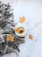 marble background with coffee Cup, leaves, scarf. Autumn composition. fall, thanksgiving day concept. Flat lay. copy space