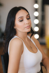 Portrait of young attractive woman with beutiful makeup in beauty studio salon. Evening make up
