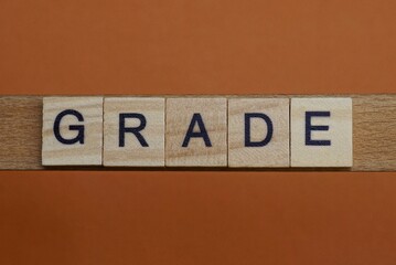 gray word grade made of wooden square letters on brown background