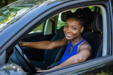 Portrait of happy young african american woman driving a car