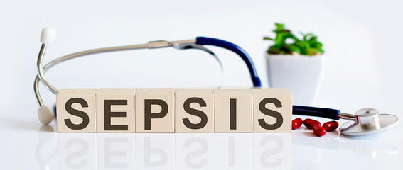 SEPSIS the word is written on wooden cubes and sthetoscope and piils . Medical concept