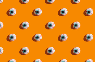sunlight pattern made with marmalade in form of monster eyes on bright orange background. Funny holiday flat lay concept.