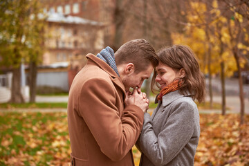 Fototapeta premium Young beautiful couple walking and hugging in the autumn park 