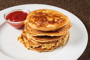 pancakes with strawberry sauce on the white plate