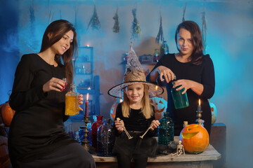 family of witches with potions and Halloween pumpkins at home