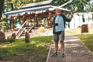 An elderly European tourist against the background of an ancient Asian temple. One day trip.