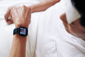 Mature man using application on smartwatch to get consultation from his doctor