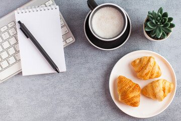 White notebook, coffee and croissant. Blank page of the Notepad to enter text. Copy space. Life style. Flat lay.