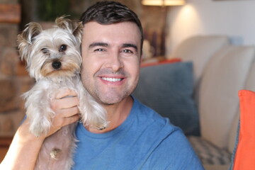 Man in sofa with small dog 