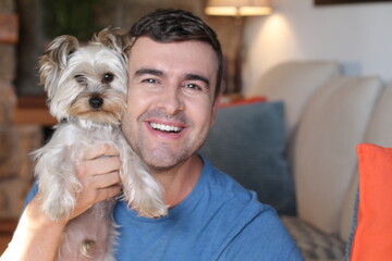 Man in sofa with small dog 
